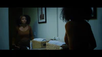 a woman in a brown top standing in front of a mirror
