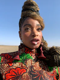a woman in a colorful dress is standing in the desert