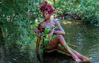 a woman in a green dress sitting in a river